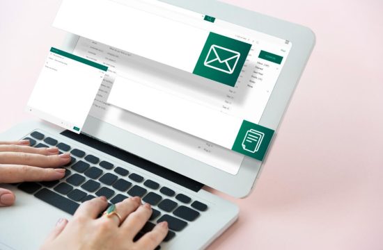 maos-sobre-notebook-cinza-com-icones-de-email-marketing-no-ecommerce-em-tons-de-verde-e-branco
