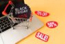 carrinho-de-compras-de-alto-angulo-em-cima-de-laptop-com-promocao-black-friday