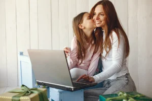 mulher-com-filha-usando-computador-portátil