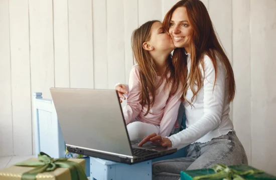 mulher-com-filha-usando-computador-portátil