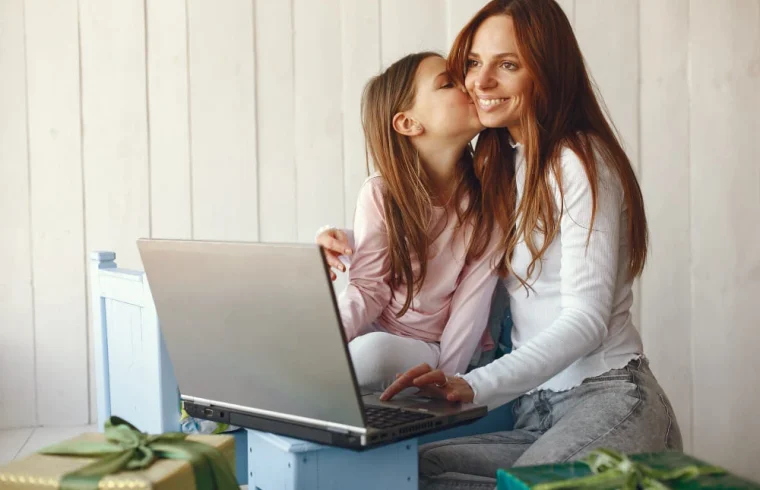 mulher-com-filha-usando-computador-portátil