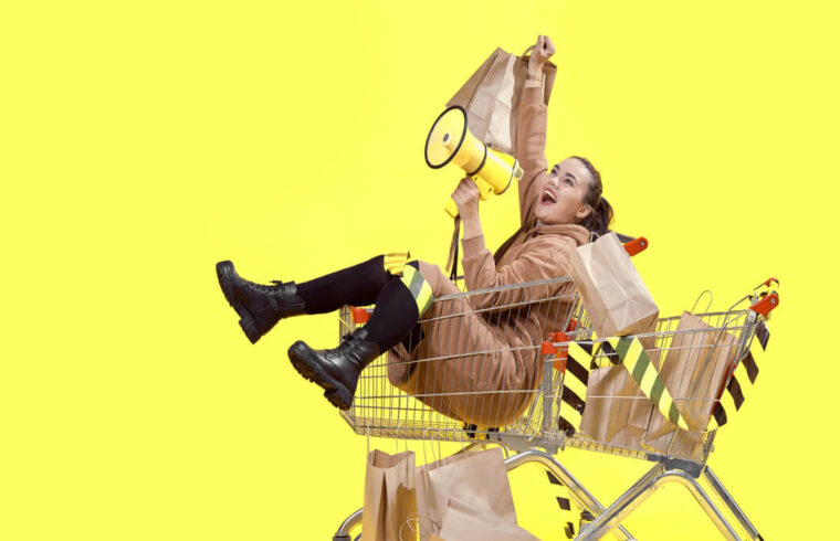 mulher-sobre-carrinho-de-compras-com-faixas-em-preto-e-amarelo-ilustrando-as-vendas-de-inicio-de-ano