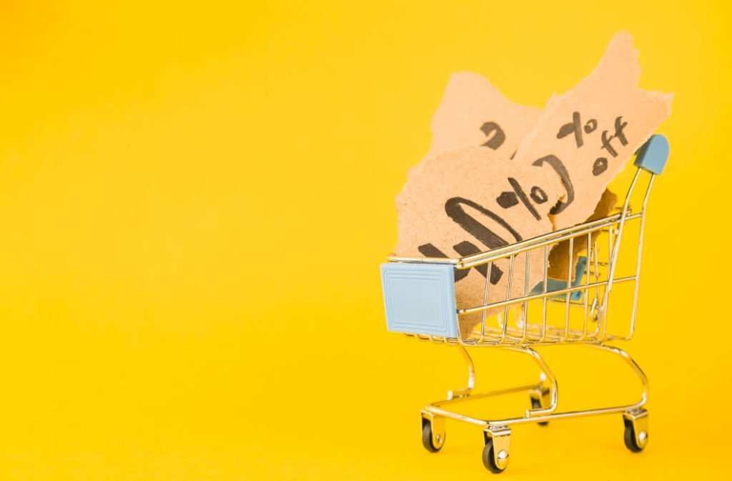 carrinho-de-compras-com-tags-de-desconto-em-fundo-amarelo-simbolizando-o-dia-do-consumidor